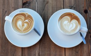 Two cappuccinos in white cup and saucers
