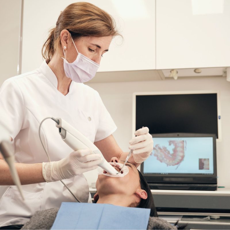 Dental professional using intraoral scanner to capture digital impressions of patient's teeth