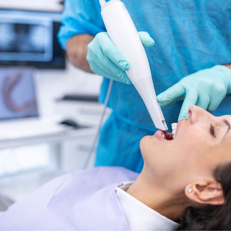 Close-up of intraoral scanner capturing 3D digital image of patient's teeth and bite