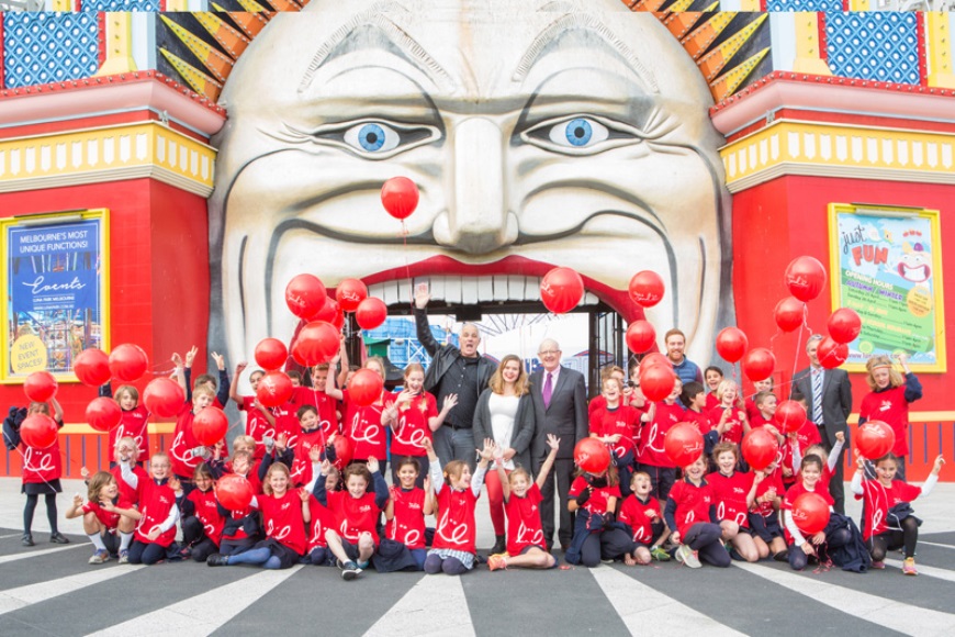 People in red gather for Give a smile out the front of Lunar Park Australia