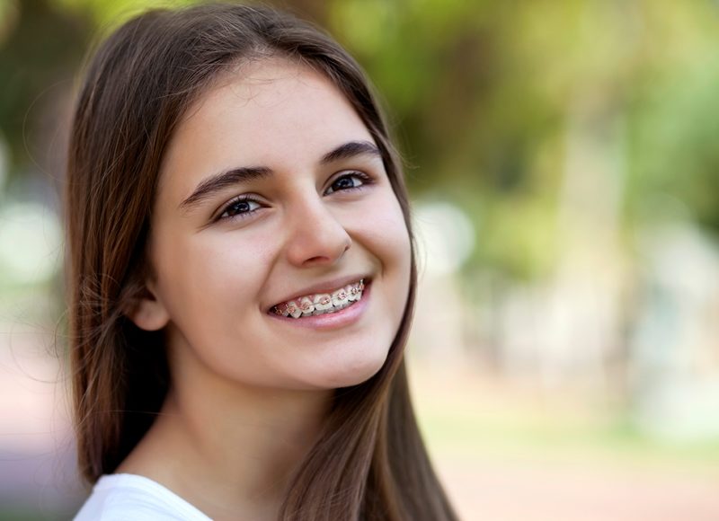 Beautiful teenage girl with braces smiling outside