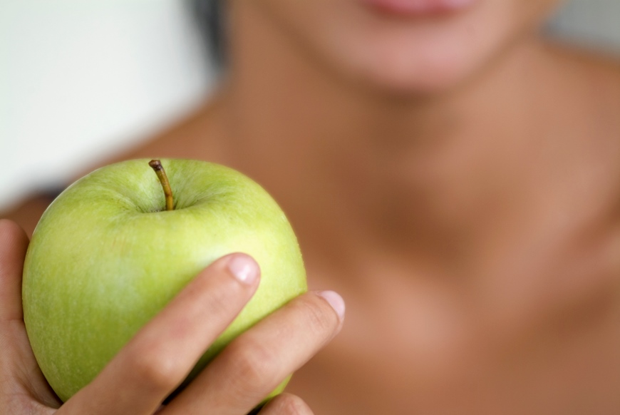 A person holding an apple