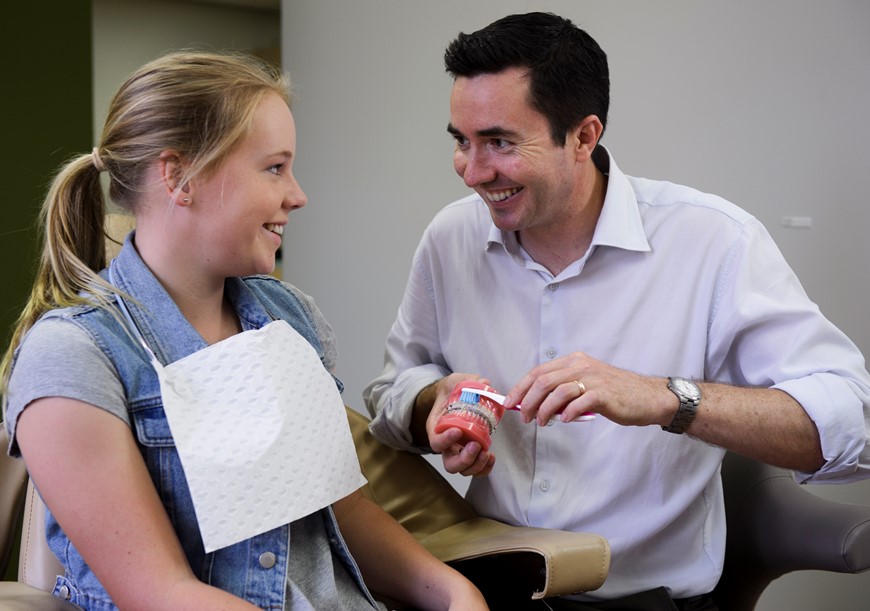Oral health therapist explaining a concept to teenage client