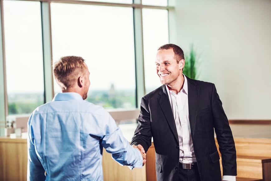 Two young business people shaking hands