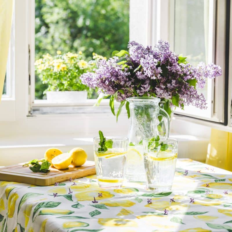 Glasses of soda water with flowers in window