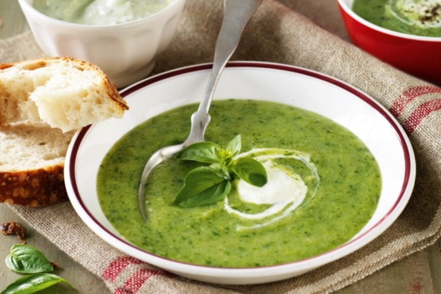 broccoli, spinach and potato soup in white bowl with bread