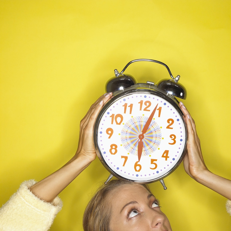 Woman holding clock over her head